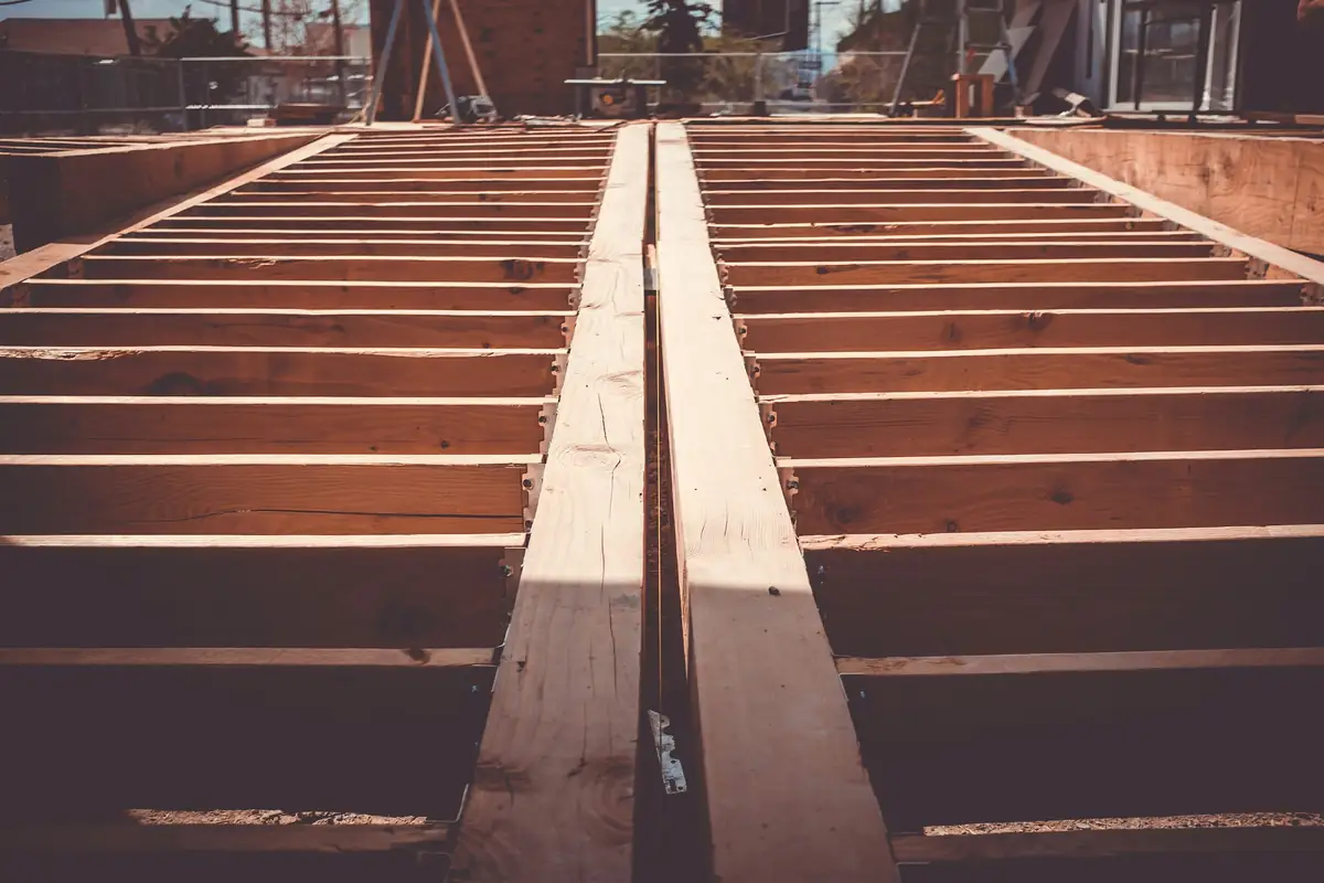 Wood floor joists on metal hangers before the boards go down